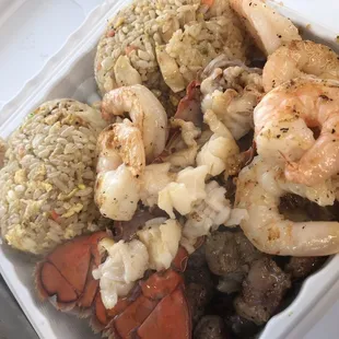 shrimp, crab, and rice in a styrofoam container