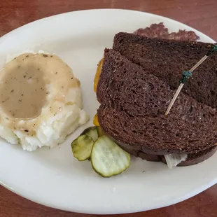 Patty Melt on Reuben with a side of mashed potatoes and gravy