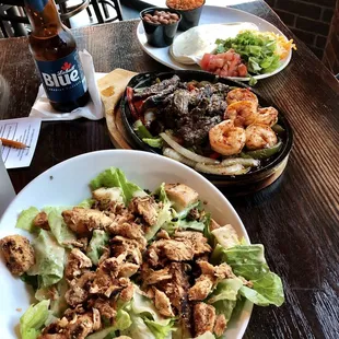 Front: Caesar Salad with chicken.  Back: Fajitas with steak and shrimp