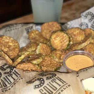 a basket of fried zucchini with a side of coleslaw