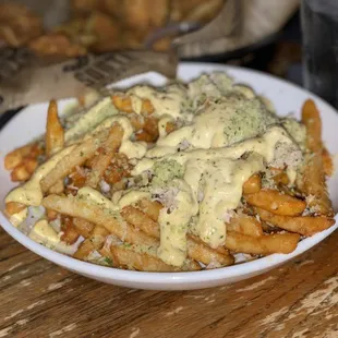 a plate of fries covered in cheese sauce