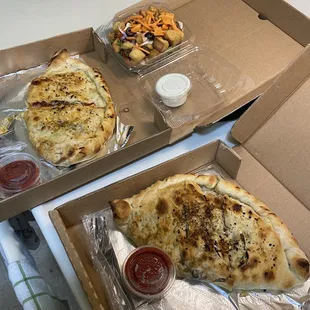 The take-out of the Meats and Mediterranean calzones and a House salad.
