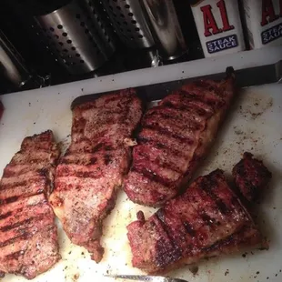 steaks on a cutting board with a knife