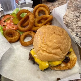Cheeseburger, homemade bun, and onion rings.