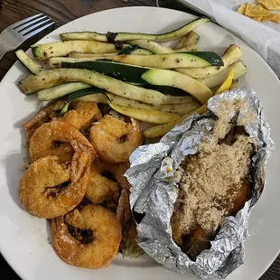 Friend shrimp on a bed of rice with a loaded sweet potato and haystack veggies.