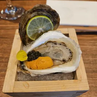 a plate of oysters with a lemon wedge