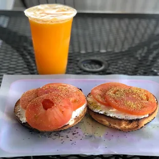 Poppy Seed Bagel topped with Cream Cheese and Tomatoes  and a small Fresh Orange Juice
