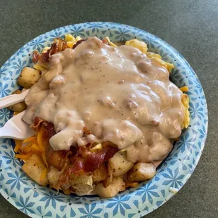 Breakfast now. Eggs And fries bacon cheese and sausage gravy