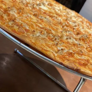 a cheese pizza on a stand