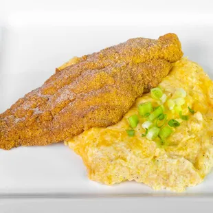 a fried fish fillet and grits