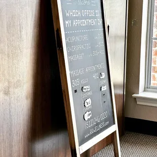 a chalkboard sign in front of a window