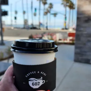 a hand holding a coffee cup