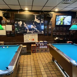 two pool tables and a television