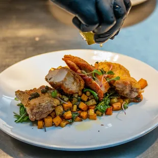 a plate of food being sprinkled with olive oil