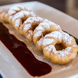 a plate of powdered sugared donuts
