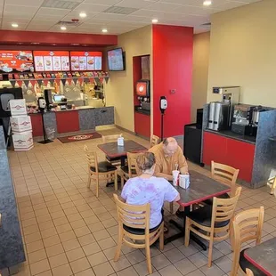two people sitting at a table in a fast food restaurant