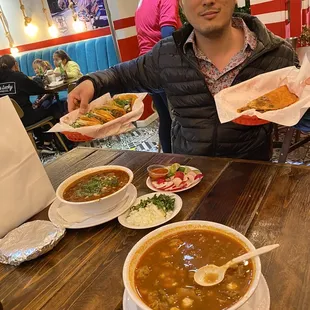 a man sitting at a table with plates of food