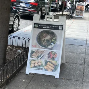 a sign on a sidewalk advertising a meal