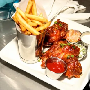 a plate of chicken wings and french fries