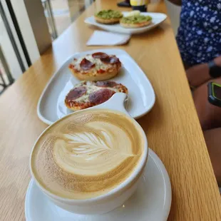 Carmel latte with pizza bagel and avocado bagel trailing after