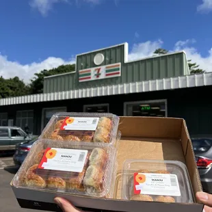 a person holding a box of donuts