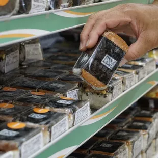 a person picking a sandwich from a shelf