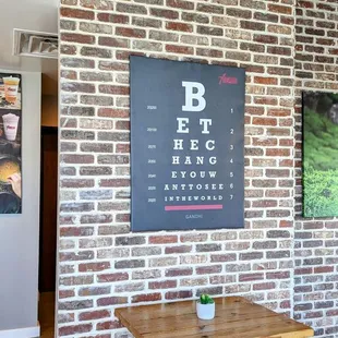 a table and chairs in front of a brick wall