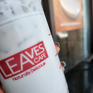 a hand holding a cup of iced coffee