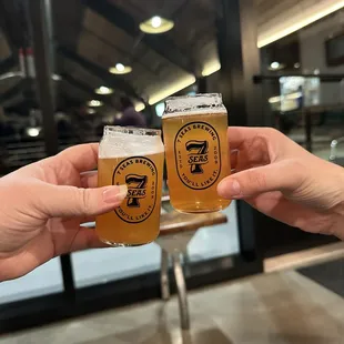 two people toasting their beers