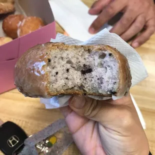 a hand holding a half eaten donut