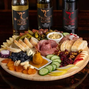 a platter of charcutette, cheese, crackers, and fruit