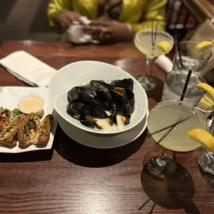 a bowl of mussels and a plate of food