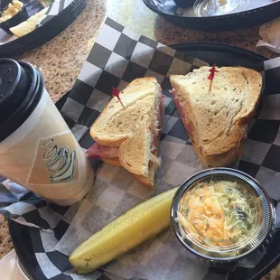 Original Reuben sandwich with coleslaw, pickle, and cappuccino.
