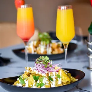 a plate of food and two glasses of orange juice