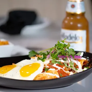 a bowl of food and a bottle of beer
