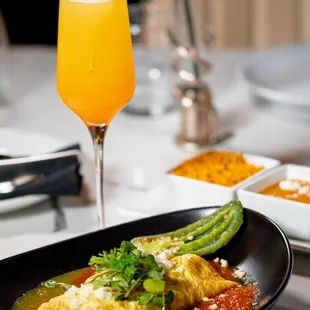 a plate of food and a glass of orange juice