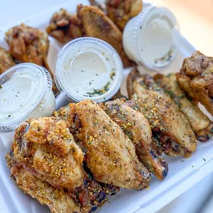 a person holding a tray of chicken wings