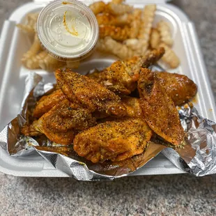 a tray of chicken wings and fries