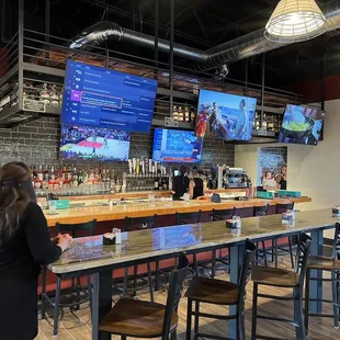 a woman standing at a bar in a sports bar