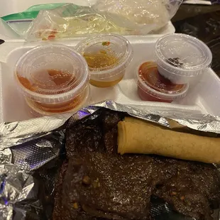 Laos jerky combo with sticky rice, Laos egg roll, papaya salad, and several sauces