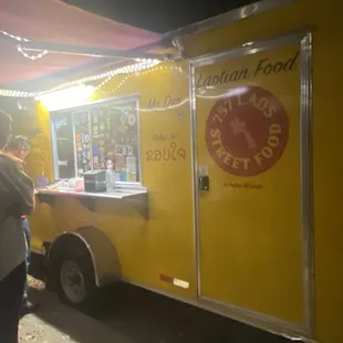 a woman standing in front of a food truck
