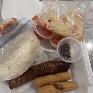Just opened up the box - Sticky rice, papaya salad, sausage and eggrolls. Came with 5 different sauces.