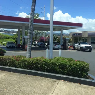 a gas station with cars parked in front of it