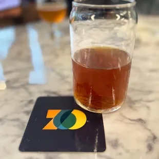 a glass of beer on a coaster