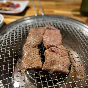 two steaks on a grill