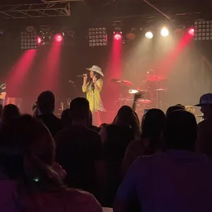 a man in a cowboy hat singing into a microphone