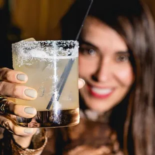 a woman holding a margarita