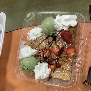 Crepe with green tea ice cream, strawberries, Nutella, and whipped cream