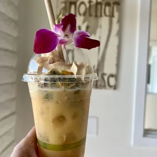 a hand holding a cup of iced coffee