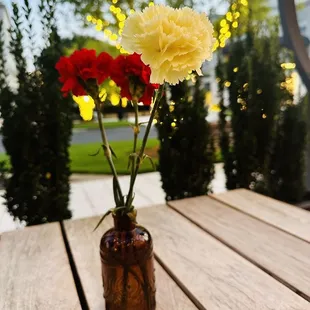 carnations in a vase on a wooden table